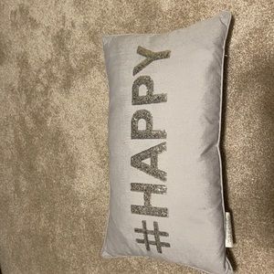 Grey rectangle pillow that has “#be happy”